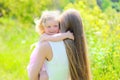 Sunny portrait of happy child hugging mother in summer Royalty Free Stock Photo