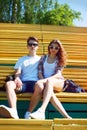 Sunny portrait of stylish young carefree couple sitting in park Royalty Free Stock Photo