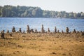 Sunny riverside landscape of a dried river bed and rocks. Stone balancing constructions near the river. Royalty Free Stock Photo