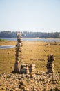 Sunny riverside landscape of a dried river bed and rocks. Stone balancing constructions near the river. Royalty Free Stock Photo
