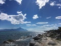 Sunny rocky coast with cloudy sky and trees