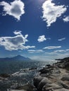 Sunny rocky coast with cloudy sky and trees