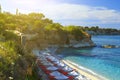 Sunny sandy beach in sea Bay of resort village. Views of mountain, shore, washed by waves and sun loungers with parasols