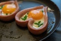 Sunny side up eggs and sausages in a pan. Two heart-shaped sausages and sliced green onions. Ready-to-eat food. Love, relationship Royalty Free Stock Photo