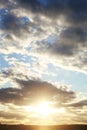 Sunny sky with sun rays shining from behind clouds in blue and yellow colors Royalty Free Stock Photo