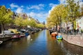 Sunny spring day in Amsterdam. Canal view with boats and bicycles, Netherlands Royalty Free Stock Photo