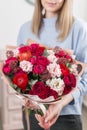 Sunny spring morning. Young happy woman holding a beautiful luxury bouquet of mixed flowers. the work of the florist at