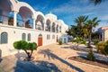 Sunny spring view of garden at Fira Orthodox Cathedral. Colorful morning scene of the famous Greek resort - Thira, Santorini,
