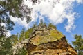 Looking up at a multi-colored stone bluff beneath a bright blue sky Royalty Free Stock Photo