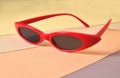 Sunny stylish glasses in bright red frames on a colored background, concept