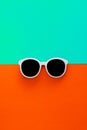 Sunny stylish white sunglasses on a bright blue-cyan and red-orange background, top view, isolated. Copy space. Flat lay Royalty Free Stock Photo