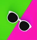 Sunny stylish white sunglasses on a bright green-cyan and crimson-pink background, top view, isolated. Copy space. Flat lay