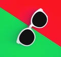 Sunny stylish white sunglasses on a bright green-cyan and red-orange background, top view, isolated. Copy space. Flat lay Royalty Free Stock Photo