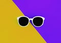 Sunny stylish white sunglasses on a bright purple-lilac and yellow-orange background, top view, isolated. Copy space. Flat lay Royalty Free Stock Photo