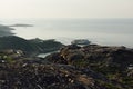 Sunny summer arctic landscape sunset with sea view - slope of granite shore and calm Barents Sea.