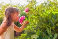 Happy little girl smelling fragrant pink peonies Royalty Free Stock Photo