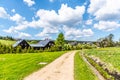 Sunny summer day in Jizerka mountain village. Dusty country road, green meadows and blue sky with white clouds, Jizera Royalty Free Stock Photo