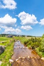 Sunny summer day in Jizerka mountain village. Jizerka river, green meadows and blue sky with white clouds, Jizera Royalty Free Stock Photo