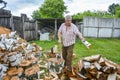 On a sunny summer day, a man is chopping firewood in the yard