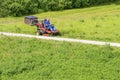 Sunny summer day.Mature man driving grass cutter in a sunny Gardener driving a riding lawn mower in a gardenay.Worker mowing grass Royalty Free Stock Photo