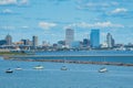 Downtown Milwaukee as seen on a Summer day from beyond a harbor with a few boats.