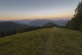 On a sunny summer day, the view from the plateau to the forest and mountains. Blue sky, lots of green grass and trees. Royalty Free Stock Photo