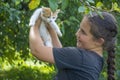 In the summer in the village, a girl holds a white-red little kitten in her arms Royalty Free Stock Photo