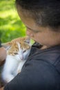 In the summer in the village, a girl holds a white-red little kitten in her arms Royalty Free Stock Photo