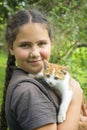 In the summer in the village, a girl holds a white-red little kitten in her arms Royalty Free Stock Photo