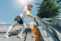 Sunny summer day. Young woman doing stretching exercises outdoor. Girl doing warm-up on steps before training. Workout. Royalty Free Stock Photo