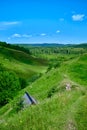 Sunny summer landscape with river. Green hills and meadows. Fields of lush green grass