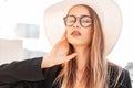 Sunny summer portrait cute young woman with beautiful lips in fashionable glasses with long hair in stylish black jacket in Royalty Free Stock Photo