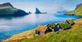 Sunny summer scene of Bour village with typical turf-top houses and Tindholmur cliffs on background. Panoramic morning view of Vag Royalty Free Stock Photo