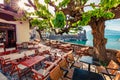 Sunny summer scene of outdoor cafe in Nafpaktos town. Colorful morning scene of Gulf of Corinth, Greece, Europe. Bright Mediterran