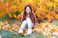 Sunny weekend. Autumn warm. Stylish smiling girl in a autumn park. Fallen leaves. Autumn nature. Happy small kid