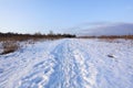 Sunny winter day in nature. The trail of human footprints in the snow goes into the distance Royalty Free Stock Photo