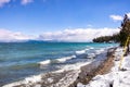 Sunny winter day on the shoreline of Lake Tahoe, Sierra mountains, California; breaking surf created by the wind crashing on the Royalty Free Stock Photo