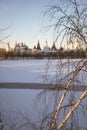 Sunny winter landscape in Moscow Russia. Pond covered with snow. Wooden old styled buildings. Izmaylovo district