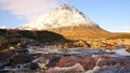 Sunny winter morning at frozen river Coupall at delta to river Etive. Snowy cone of mountain Stob Dearg 1021 metres high.