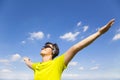 Sunny young man enjoying music with blue sky