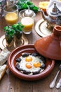 Sunnyside Eggs cooked in a Tajine dish with beef, Moroccan breakfast with juice and mint tea Royalty Free Stock Photo