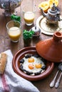 Sunnyside Eggs cooked in a Tajine dish with beef, Moroccan breakfast with juice and mint tea Royalty Free Stock Photo