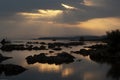 Sunrays break through the clouds over tufa silhouettes at Mono Lake during sunrise