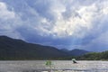 Sunrays breaking through storm clouds over mountain lake