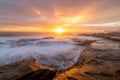 Sunrays burst forth from sunrise sun on beautiful coastline