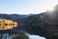 Sunrays bursting over mountain range and glowing on auatumn lake Royalty Free Stock Photo