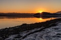 Sunrays on evening sky during sunset with snow on the beach Royalty Free Stock Photo