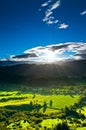 Sunrays flood farmland during sunset