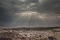 Sunrays through a gap in the overcast sky with black clouds with golden silver lining Royalty Free Stock Photo