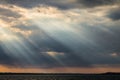 Sunrays at near sunset, with dark clouds in the background, above Trasimeno lake Umbria, Italy Royalty Free Stock Photo